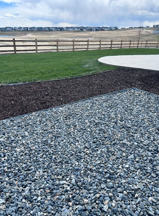 Backyard with rock bed, mulch border, sod and paver patio