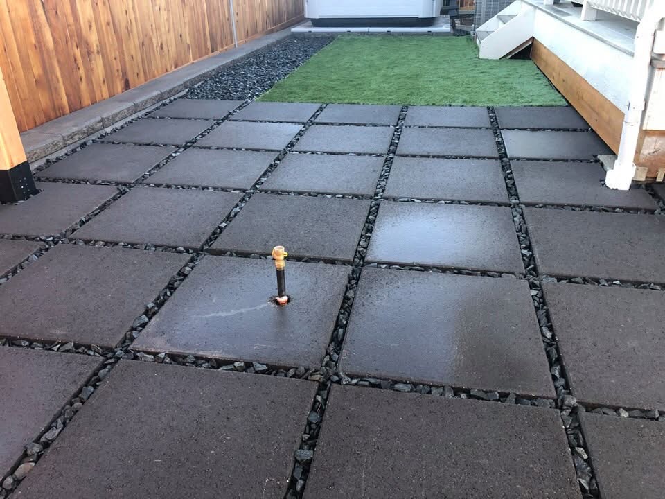 Paver patio with rock joints and turf area in a Denver backyard