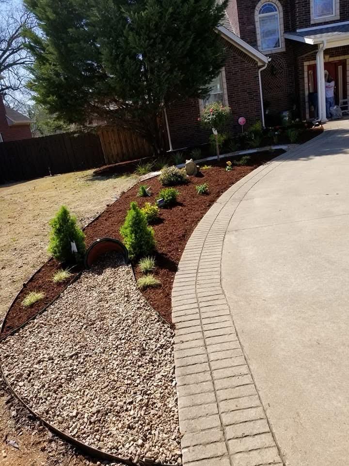 Front yard redesign with curved mulch beds, rock and new plantings