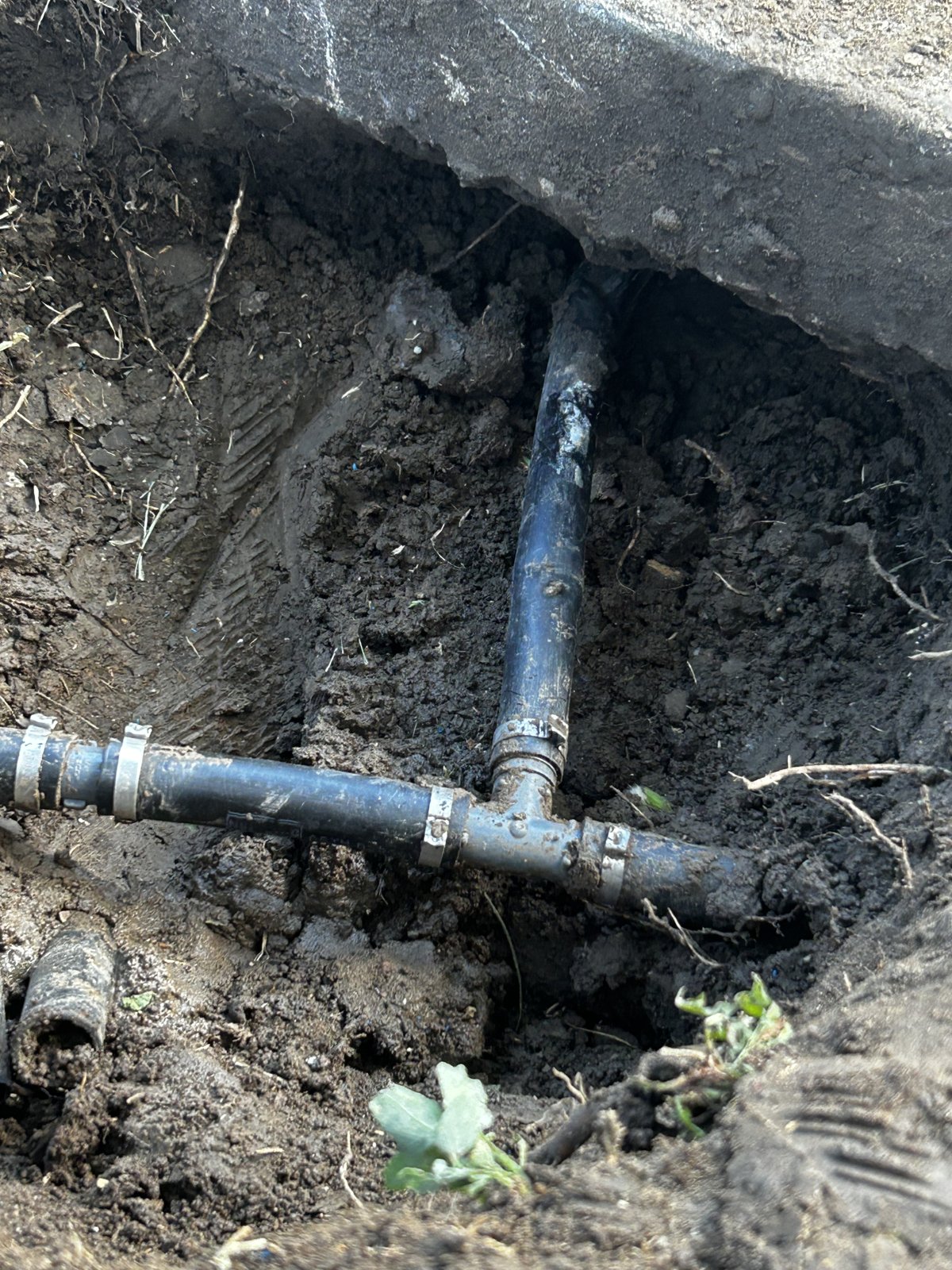 Repaired underground irrigation line and fittings in an excavated trench