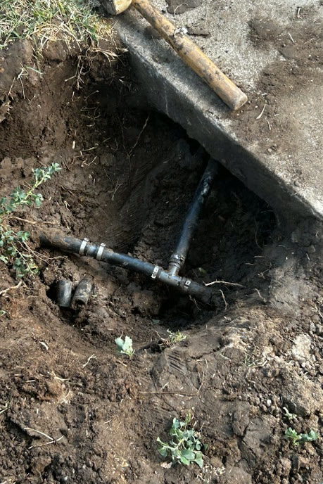 Excavated irrigation main line under a concrete slab